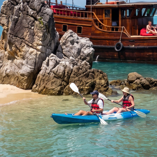 Private Angthong Marine Park Sailing Charter – guests kayaking between limestone rocks with the junk behind – TourInKohSamui.com